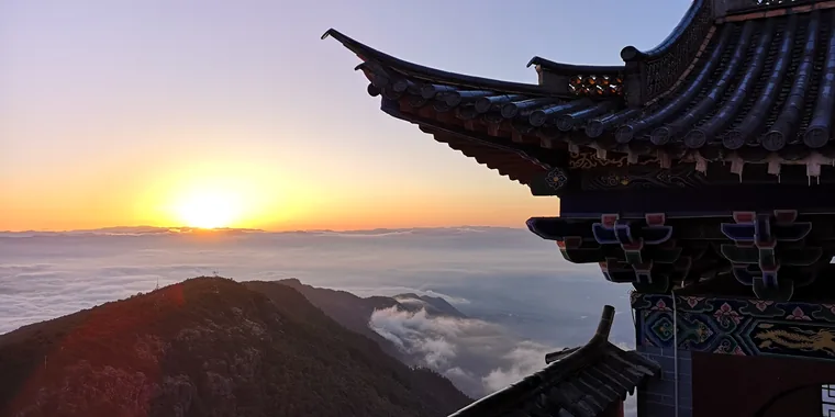 鸡足山金顶寺檐角与日出山景
